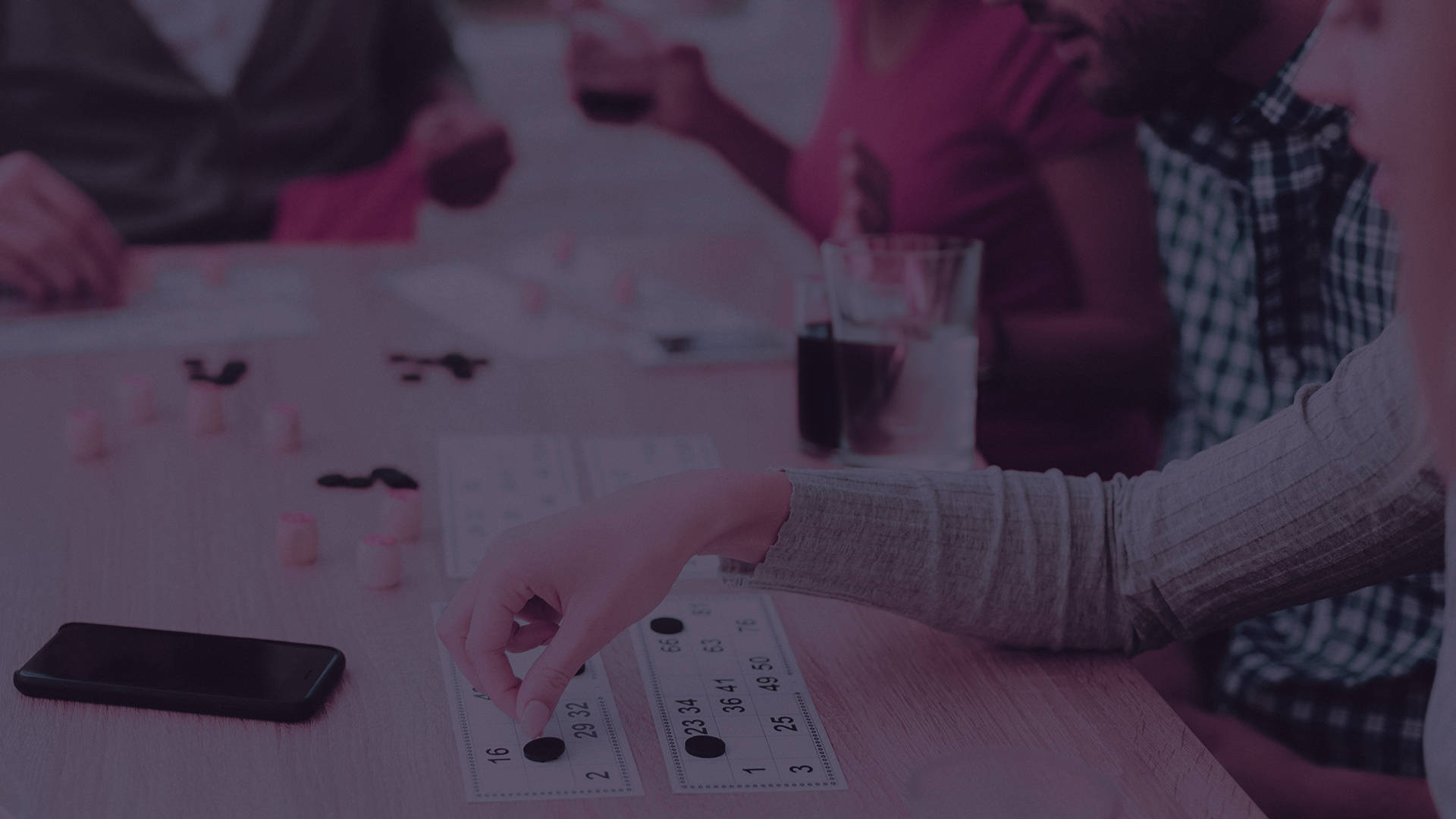 People playing a game with cards and markers at a table.