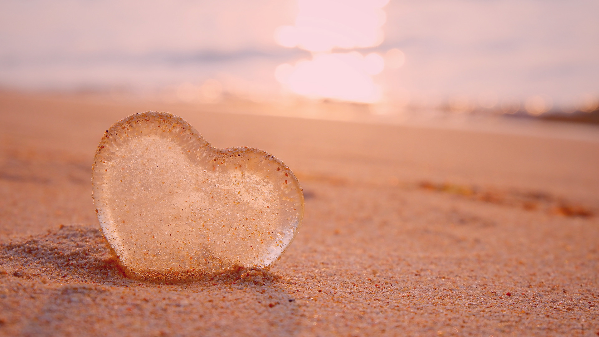 image of a glass heart on a beach