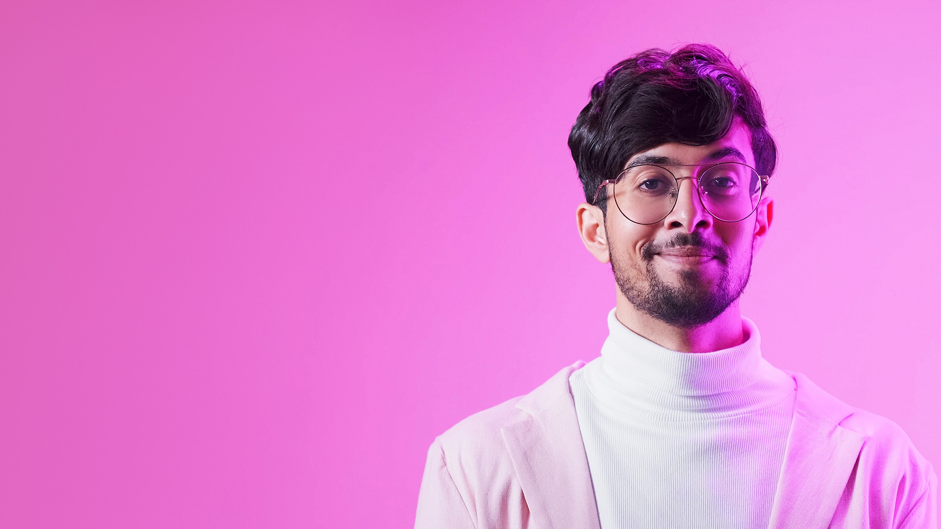 man smiling in front of a pink background